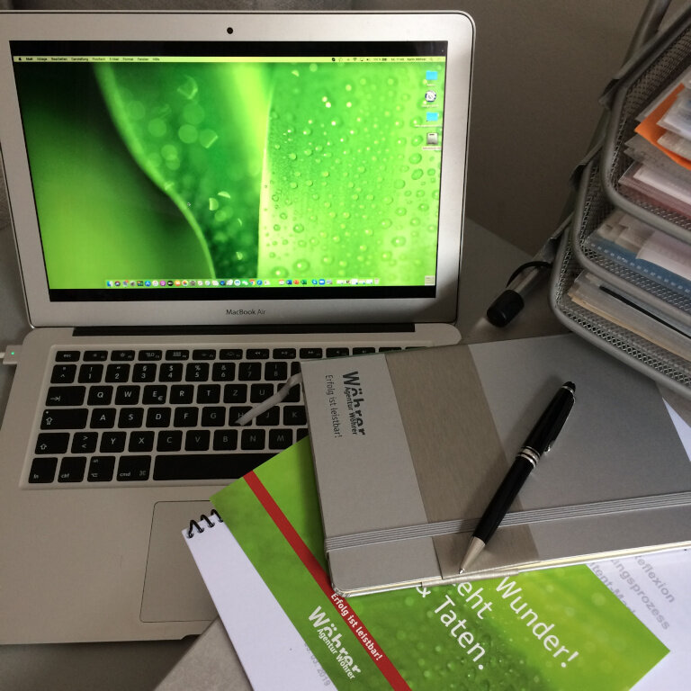 Arbeitsplatz der Agentur Wöhrer mit einem Laptop und Stiften